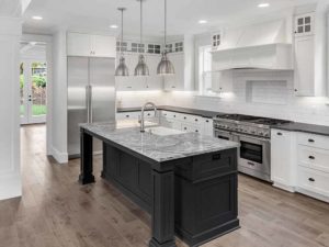 Kitchen with wooden flooring, stainless steel appliances, and finished countertops | MTP Construction