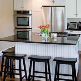 Kitchen island countertop and stools placed around it